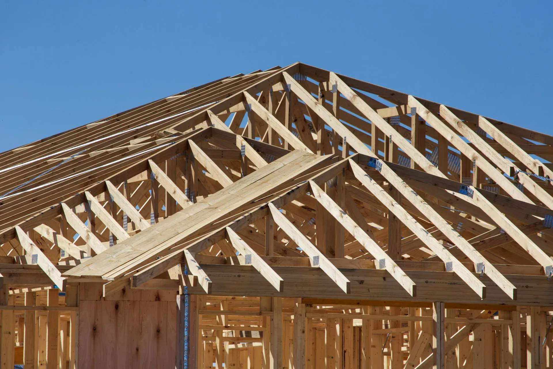 House under construction with wood framing and roof trusses (representative image)